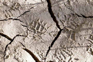 Footprints of human footsteps on broken and dry ground