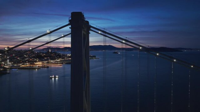 Flight over night illuminated San Francisco city downtown. Aerial night traffic on Bay Bridge with downtown evening panorama 4K. Downtown San Francisco buildings skyline at night with scenic dusk sky