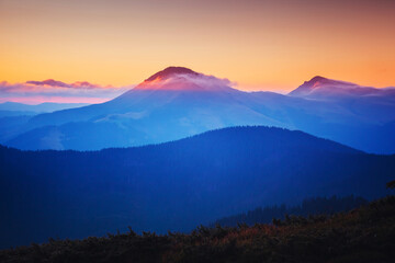 A majestic view of the mountain ranges illuminated by the sunset.