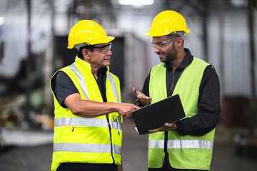 technician, supervisor with a senior foreman holding a walkie-talkie to command or inspect work with a checklist computer The background is an industrial warehouse.