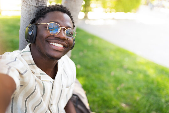 Young black man taking selfie outdoors.Smiling, happy, African american male with glasses looking at camera.Copy space.