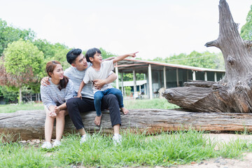 Image of young Asian family playing together at park