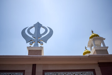 Khanda Sikh holy religious symbol at gurudwara entrance with bright blue sky image is taken at Sis...