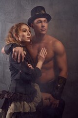 Stylish ethnic couple embracing in studio and looking at light