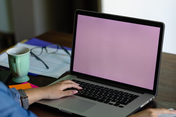 Hand of biracial woman using laptop with copy space on screen, working from home