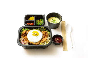 Spicy stir-fried meat and side dishes in a take-out container