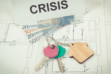 Keys with house shape, euro and inscription crisis on housing plan. Crisis of real estate market. Reduced housing prices