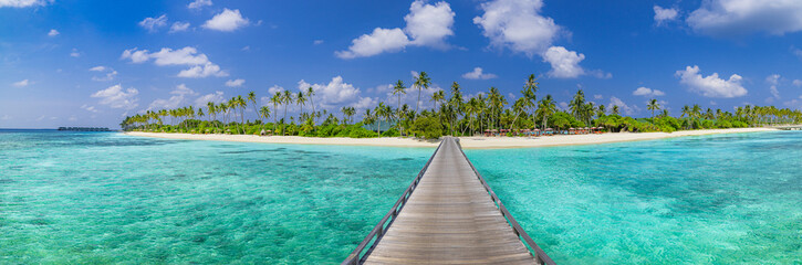 Luxury travel landscape. Water villas, wooden pier bridge leads to palm trees over white sandy...