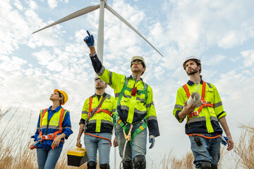 Teamwork engineer worker wearing safety uniform discuss operational planning at wind turbine field renewable energy. technology protect environment reduce global warming problems. © eakgrungenerd