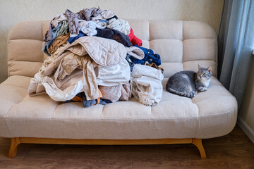 Fototapeta na wymiar Sorting clothes after washing. Pulling the home sofa clothing