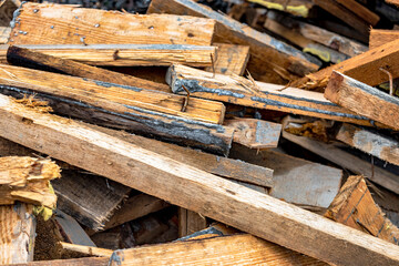 Construction waste after dismantling the formwork of a reinforced concrete foundation. Utilization of construction waste. Old boards, beams and formwork panels at a construction site.