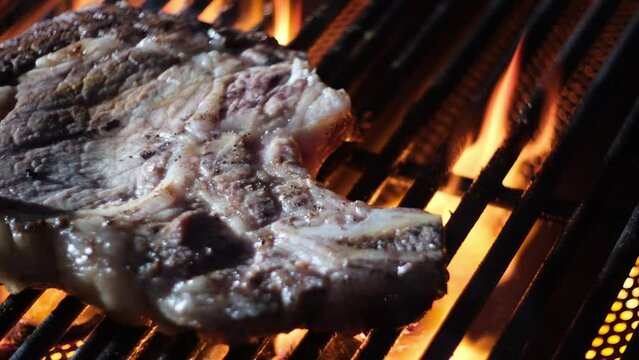 Flaming grill with meat beef grilled on barbecue. Meat prepared on barbecue grill on fire. Grilled meat. Roast beefsteak. Flaming charcoal grill with beef steak. Grilling, barbecue, bbq and grill.