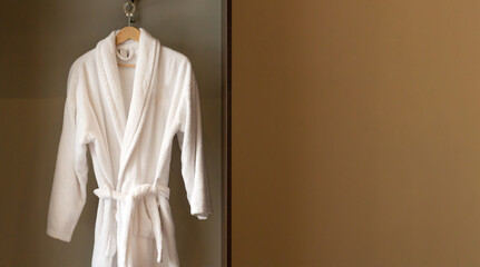Hanger with clean white bathrobe in hotel wardrobe - obrazy, fototapety, plakaty