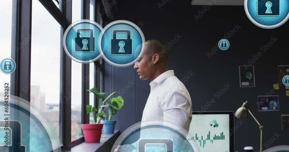 Poster animation of security padlock icons floating against biracial man looking out of window at office