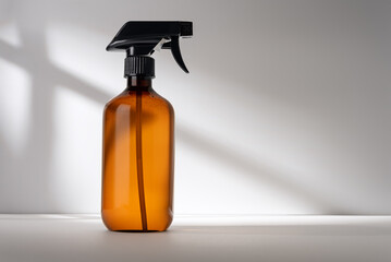 Single brown spray bottle on gray background with shadows