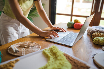 Small business. smiling young entrepreneur Asian Woman. Punch needle craftswoman with laptop computer. in studio workshop. Handmade craft handicraft items