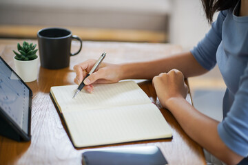 Online studying class for E learning. Smart student girl sitting at table watching lesson online and studying from home.