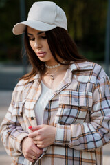 Portrait of a beautiful girl. Close-up photo of a beautiful girl in a plaid shirt and white cap
