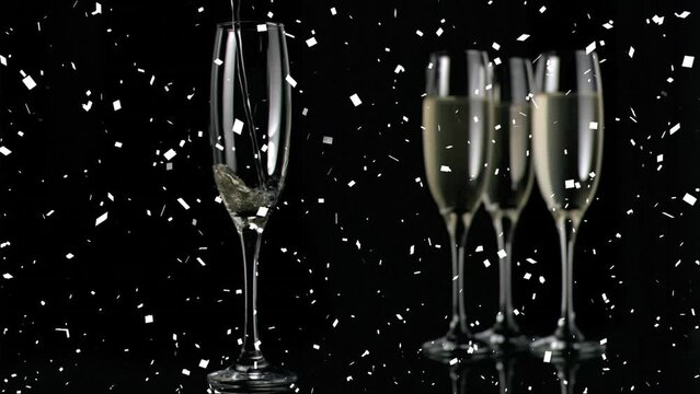Animation of falling confetti over champagne filled flute glasses against black background