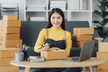 Fototapeta na wymiar tarting Small business entrepreneur SME freelance,Portrait young woman working at home office, BOX,smartphone,laptop, online, marketing, packaging, delivery, SME, e-commerce concept