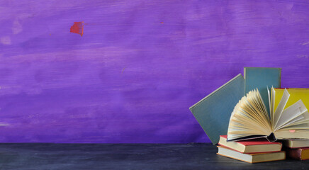 open book with stacks of books, education, knowledge, learning, reading concept on purple background, large free copy space