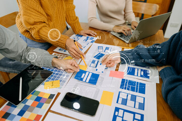 Close up view of UI developer team brainstorming on their project with laptop, smartphone and...