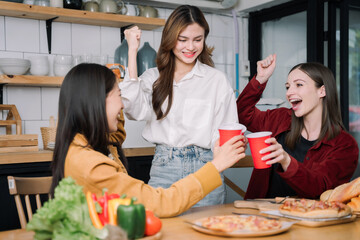 happy friends or teen girls eating pizza at home.