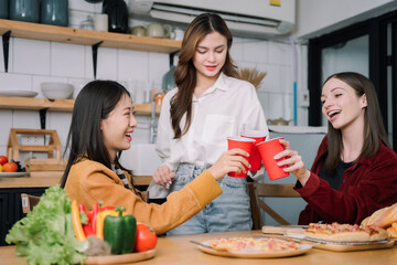 happy friends or teen girls eating pizza at home.