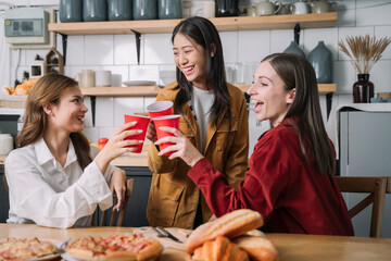 happy friends or teen girls eating pizza at home.
