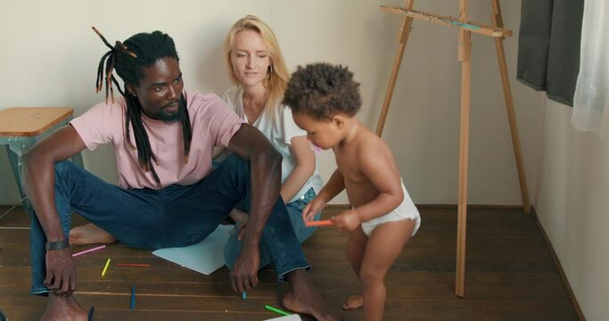 little adorable toddler wants to draw, paint, colour, Slow motion, dad and mom watching their kid parenthood