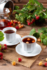 Raspberry tea with natural berries on wooden table, vitamin tea for weight loss