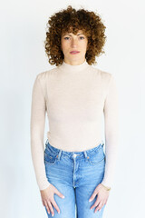 Curly haired woman standing against white background