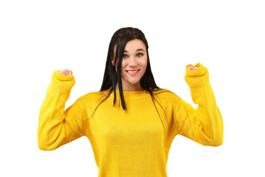 brunette girl rejoicing her success and victory clenching her fists with joy. Lucky woman in a yellow sweater smiling at the camera isolated on transparent background