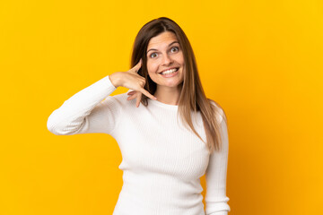 Young Slovak woman isolated on yellow background making phone gesture. Call me back sign