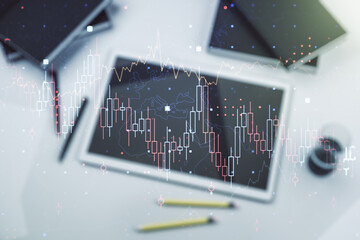 Multi exposure of abstract financial graph and modern digital tablet on desktop on background, top view, financial and trading concept