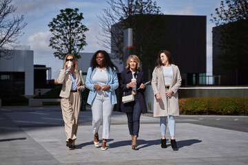 Fototapeta premium Professional and Confident Female Entrepreneurs Having a Productive Discussion While Strolling Through the Financial District, Symbolizing Success and Empowerment