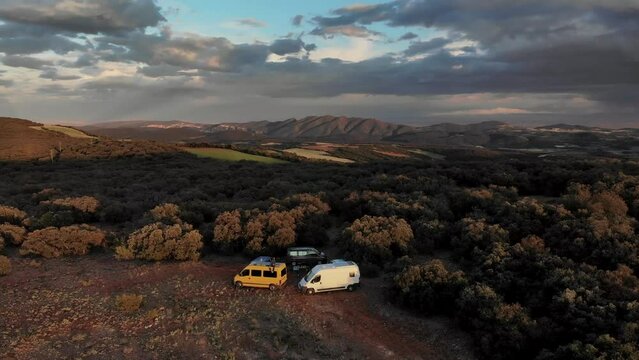 4K drone footage at sunset over people and camper vans in beautiful forest spot with huge panoramic landscape on the back, Ager, Catalonia, Spain.
Mid angle, parallax movement.