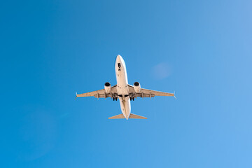 avión con tren de aterrizaje desplegado y cielo azul de fondo