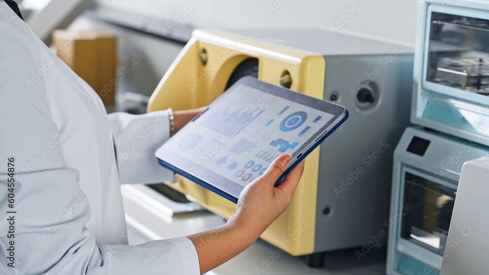Aufkleber a researcher using experimental equipment while looking at a tablet.