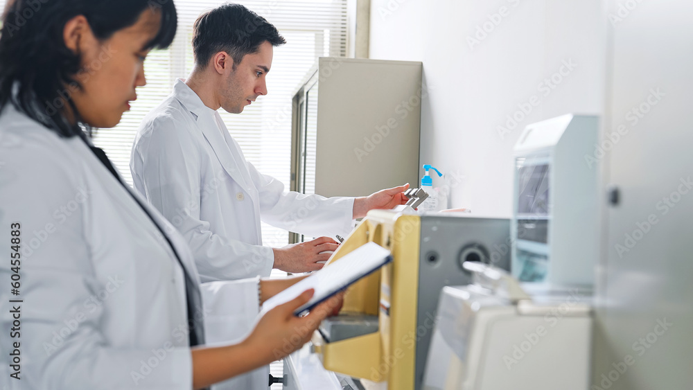 Aufkleber a researcher using experimental equipment while looking at a tablet.
