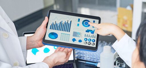 Group of researchers looking at tablet data in the lab. Research and Development.