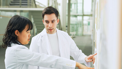 Obraz premium 研究施設で会話する白衣を着た多国籍グループ