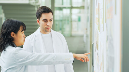 Multinational group in white coats having a conversation in a research facility.