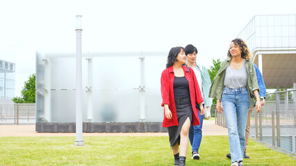 Multinational youth group walking in college campus. College students.