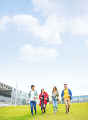 Multinational youth group running on grass field. College students.