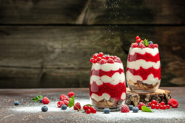 Raspberry dessert cheesecake, trifle, mouse in a glass. Raspberry Greek yogurt granola parfait on a dark background. Restaurant menu, dieting, cookbook recipe - obrazy, fototapety, plakaty