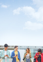 Multinational youth group walking with smart phone in college campus. College students.