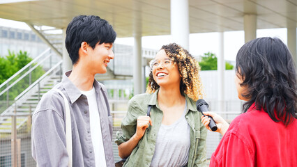 Multinational couple being interviewed on the street by the media.