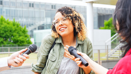 African woman being interviewed on the street by the media.