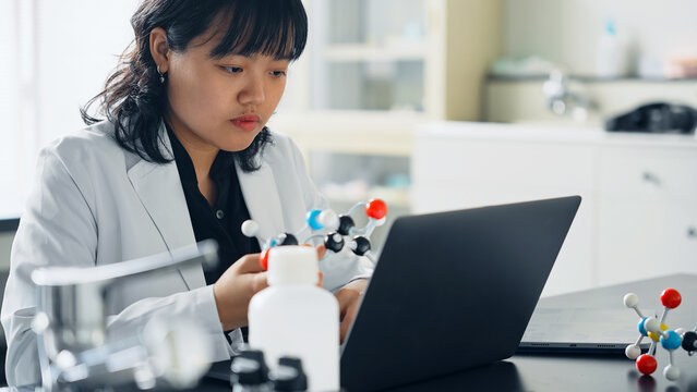 Female researcher looking at a molecular model. science student.